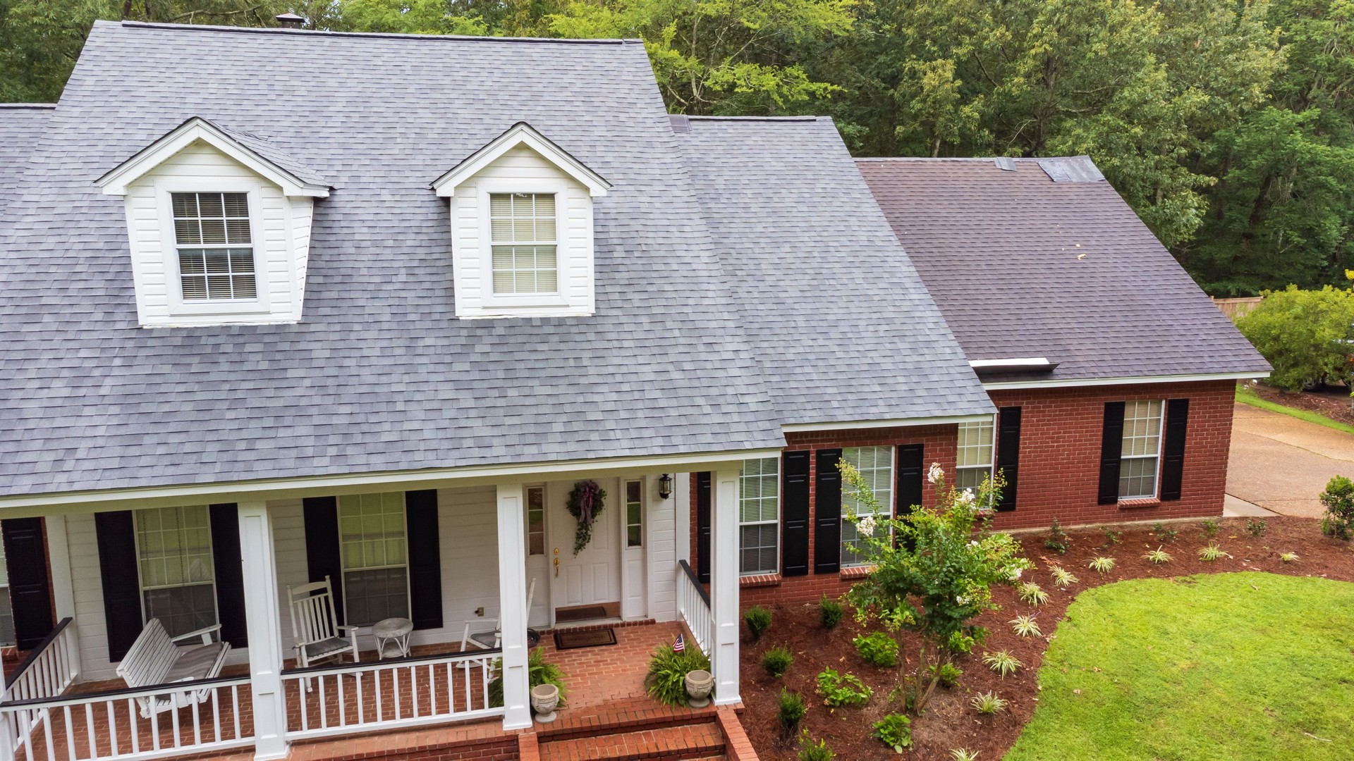 New roof and old roof on house, showing comparison of the two.